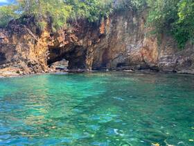 A stunning view of a natural rock formation arching over crystal-clear waters, perfect for exploring coastal landscapes and enjoying the beauty of nature.