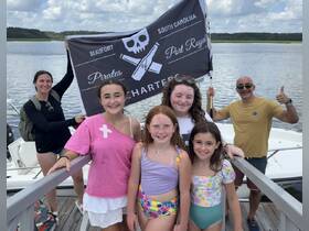 A joyful group of friends and family celebrates their boat charter in Beaufort, South Carolina, showcasing the fun and camaraderie of a day on the water.
