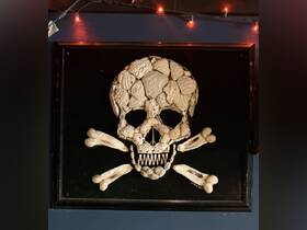 A decorative piece featuring a skull and crossbones made from various materials, creating an intriguing nautical theme.