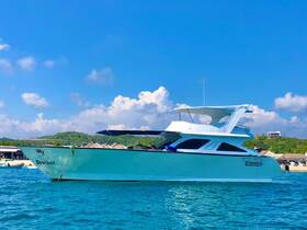 A stunning view of the yacht named 'My Brother' docked in clear waters, showcasing its sleek design against a backdrop of blue skies and lush greenery.