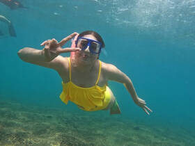 A joyful snorkeler poses underwater, showcasing the vibrant marine life and the thrill of snorkeling adventures.