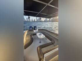 A spacious and stylish interior seating area of a boat, featuring comfortable lounge seating and a table, perfect for relaxing while enjoying views of the city skyline.