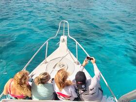 A group of friends captures a selfie on the bow of a boat, surrounded by stunning turquoise waters — a perfect moment of fun and adventure on the water.