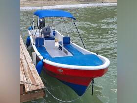 A vibrant red and blue speedboat docked at the shore, showcasing its sleek design and spacious seating — perfect for a day on the water.