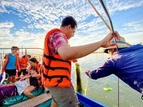 A lively family engages in fishing activities on a boat, showcasing a fun and adventurous day on the water.