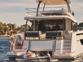 A family enjoys a fun day on a yacht, with kids playing in the water and adults relaxing on the deck — a perfect summer getaway.