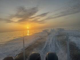 A stunning sunset view from a boat, capturing the serene beauty of the water and sky as the day comes to a close — perfect for sunset cruises.