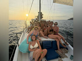 A lively group of friends enjoys a sunset celebration aboard a yacht, capturing the essence of summer fun on the water.