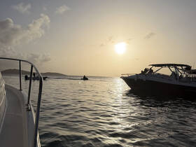 A stunning sunset view captures a jet ski in action alongside boats, creating a perfect backdrop for an adventurous evening on the water.