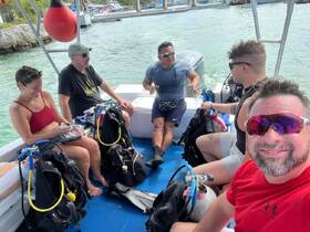 A group of divers prepares for an exciting underwater adventure aboard a boat, showcasing the camaraderie and thrill of scuba diving experiences.