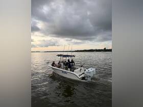 A group of friends enjoys a fishing trip aboard the Tuitto, navigating through calm waters under a dramatic sky — perfect for adventure seekers.