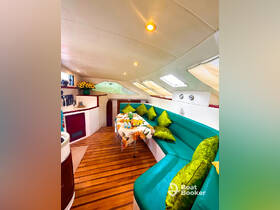 Interior view of a cozy boat cabin featuring vibrant seating and a dining area, perfect for relaxing and enjoying meals while on the water.