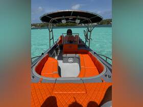 Interior view of a stylish boat featuring vibrant orange seating and a spacious helm area, perfect for comfortable cruising on clear turquoise waters.
