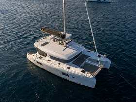 A stunning aerial view of a sleek catamaran gliding through the water, showcasing its elegant design and spacious deck, perfect for luxury sailing experiences.