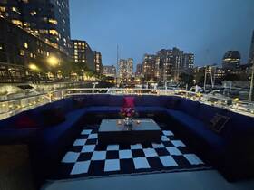 A cozy lounge area on a boat, featuring stylish seating and ambient lighting, perfect for evening gatherings or relaxing on the water.