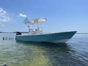 A sleek speedboat anchored in clear waters, showcasing its vibrant design and perfect for a day of fishing or leisure on the water.