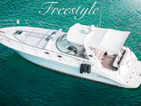 A stunning aerial view of the 'Freestyle' yacht gliding through crystal-clear waters, showcasing its elegant design and inviting deck space.