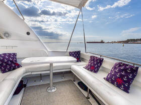 A cozy lounge area inside a boat featuring comfortable seating and a table, perfect for relaxing while enjoying scenic views of the water.