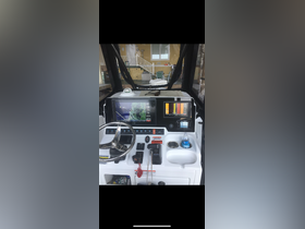 A detailed view of the helm and console area inside a boat, showcasing navigation equipment and controls, perfect for understanding the vessel's operational features.