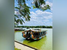 A vibrant dragon boat docked in serene waters, showcasing intricate designs and colors, perfect for scenic tours or cultural experiences.
