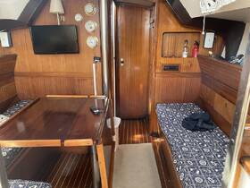Interior view of a cozy boat cabin featuring wooden finishes, seating areas, and a television, perfect for relaxing during trips on the water.