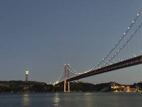A blurry image capturing a bridge and a statue at dusk, lacking clarity and detail.