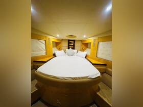 Cozy cabin interior featuring a spacious round bed and elegant wooden finishes, perfect for relaxing on a boat getaway.