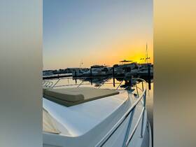 A serene sunset view from the deck of a yacht docked at the marina, showcasing the tranquil waters and surrounding boats.
