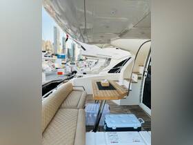 A stylish interior view of a yacht featuring comfortable seating and a dining area, perfect for relaxing and entertaining while on the water.