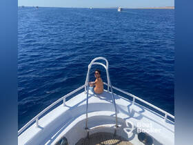 A person enjoys the serene ocean view while relaxing on the bow of a boat, capturing the essence of a perfect day on the water.