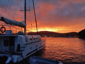 A stunning sunset view of a yacht docked by the shore, with vibrant orange and purple hues reflecting on the water — perfect for capturing the beauty of evening boat life.