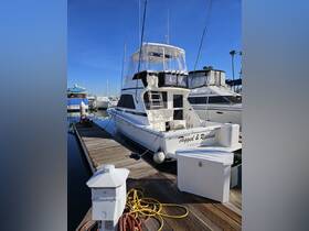 A pristine yacht named 'Tagged & Released' docked at a marina, showcasing its sleek design against a clear blue sky — perfect for fishing trips or leisure cruises.