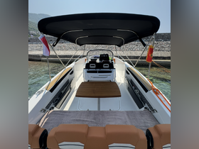 Interior view of a stylish boat featuring comfortable seating and a helm, perfect for leisurely outings on the water.