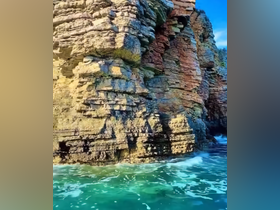 A close-up view of rocky cliffs by the water, showcasing the natural beauty of the coastline.