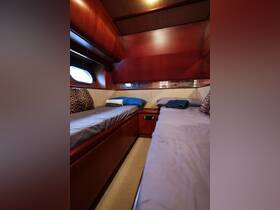 Interior view of a cozy boat cabin featuring twin beds and stylish wood paneling, perfect for comfortable overnight stays on the water.