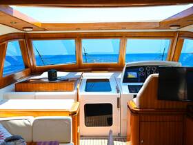 A beautifully designed helm area inside a yacht, featuring modern navigation equipment and a cozy seating arrangement, perfect for enjoying the open sea.