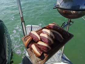 A beautifully arranged platter of grilled meats on a boat, perfect for a delicious barbecue experience on the water.