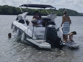 A family enjoys a fun day on the water, with kids playing and swimming around their boat, creating memorable moments in a beautiful setting.