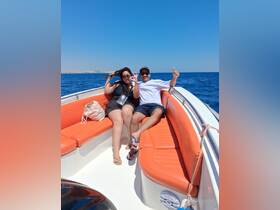A cheerful couple enjoys a sunny day on a boat, capturing the essence of fun and relaxation on the water.
