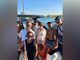 A cheerful group poses together on a boat, capturing a memorable moment during their adventure on the water.