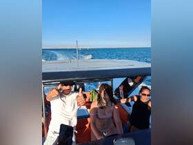 A lively group enjoys a boat ride on the ocean, showcasing the excitement of a day on the water.