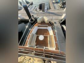 A well-appointed interior view of a boat's seating area, showcasing comfortable lounge spaces and elegant wooden flooring, perfect for relaxing on the water.