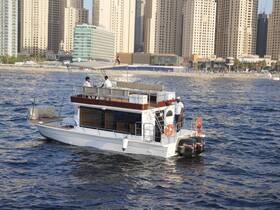 A scenic view of a boat cruising near a vibrant city skyline, with crew members on deck enjoying the ride — a perfect setting for urban boating adventures.