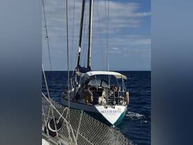 A sailboat named 'Skulmartin' navigates the open waters with passengers on board, showcasing the beauty of sailing adventures.
