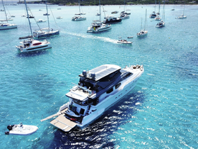 A stunning aerial view of a luxurious yacht cruising through crystal-clear turquoise waters, surrounded by other boats, perfect for showcasing the beauty of a boating adventure.
