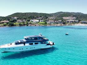 A stunning aerial view of a luxurious yacht cruising through crystal-clear turquoise waters, surrounded by picturesque coastal homes — perfect for showcasing upscale boating experiences.