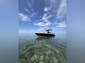 A sleek boat floats serenely in crystal-clear waters, showcasing its elegant design against a backdrop of blue skies — perfect for a day of exploration on the water.