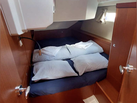 Cozy cabin interior featuring a neatly made bed with pillows, perfect for restful nights on the water.