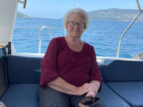 A woman relaxes in the cozy cabin of a boat, enjoying the serene views of the water and surrounding landscape.
