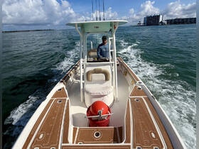 A captain navigates a fishing boat through clear waters, showcasing the thrill of being on the water and the excitement of fishing adventures.